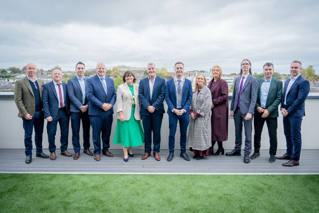 project partner representatives post for photo on building rooftop
