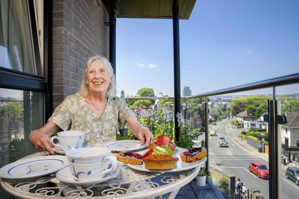 Helen on the balcony of her home smiling