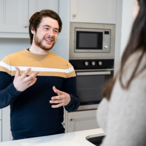 man talking to woman in kitchen