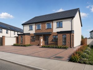 Exterior view of the one bedroom homes at Cornamaddy Court Phase 2, a pair of two storey buildings in brick and render, each with its own front door and paved driveway