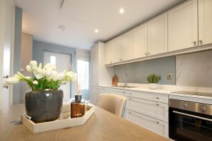 Show home kitchen and dining area at Bennetstown with cream fitted units, an integrated oven and a dining table.